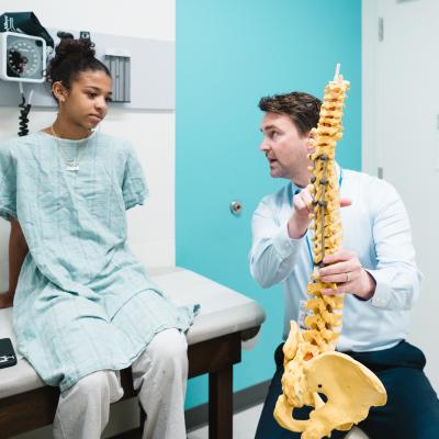 Dr. Stelzer talks with a patient in a spine clinic.
