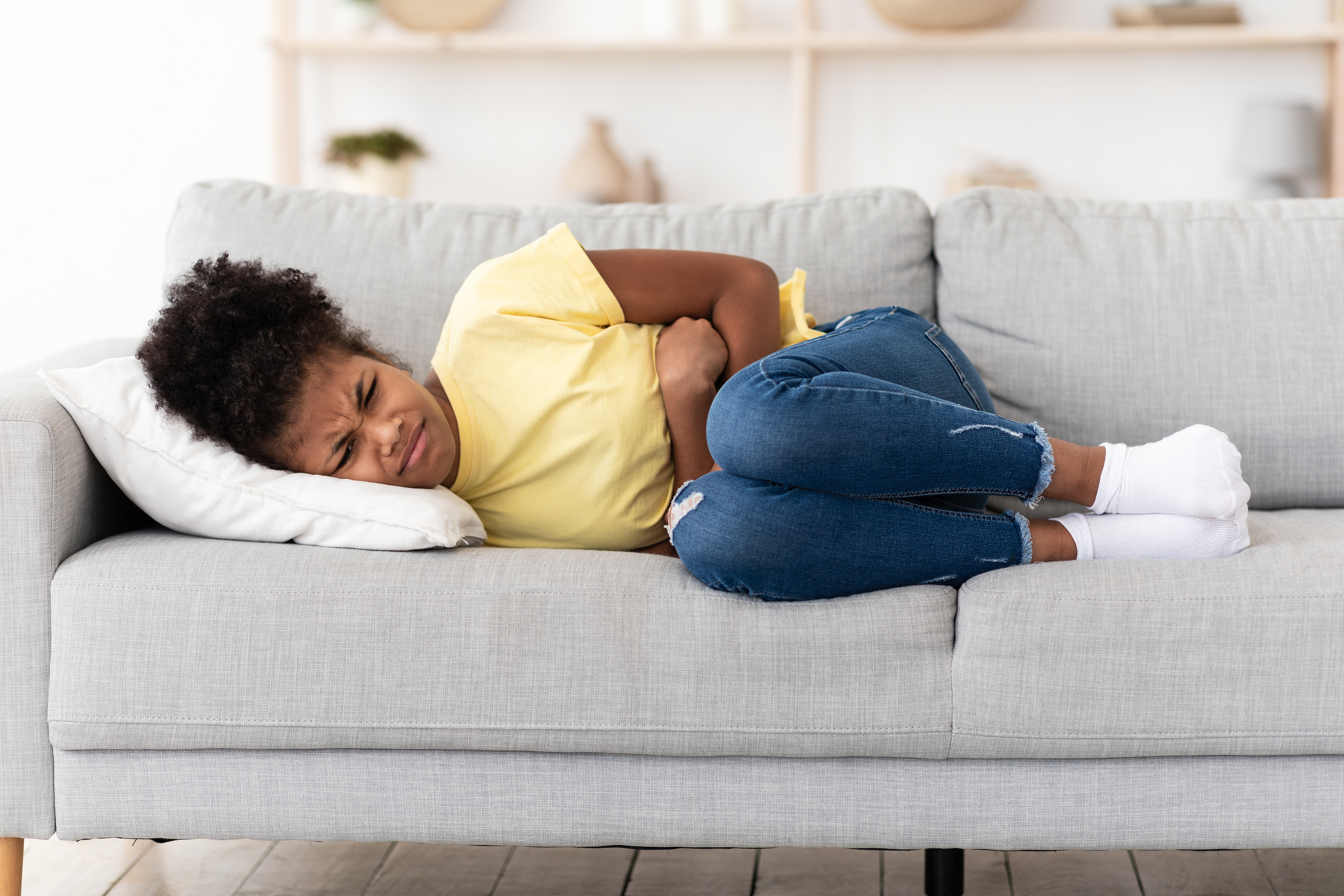 Girl with stomach pains on couch