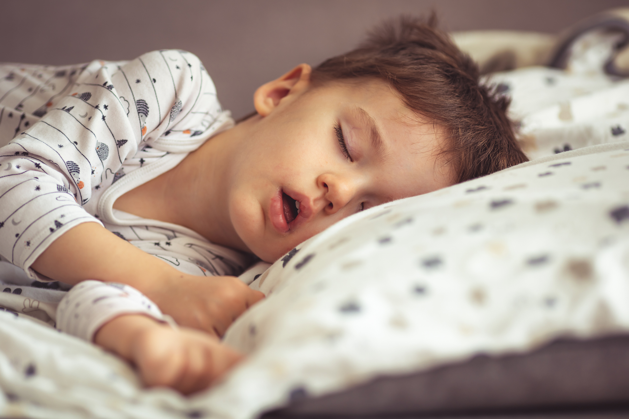 Young boy asleep in bed with mouth open, maybe mouth breathing