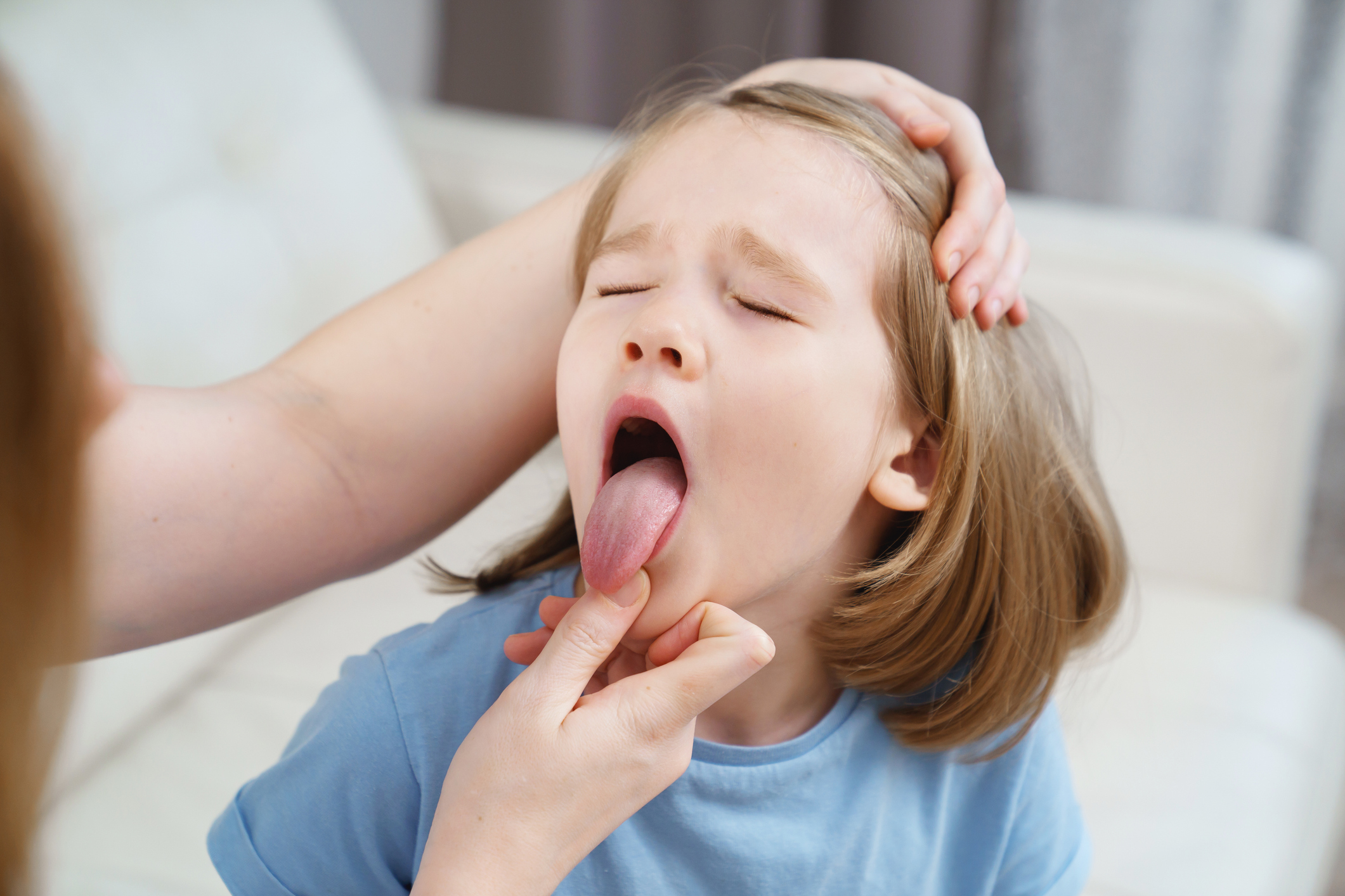 Young girl getting throat checked, tongue out