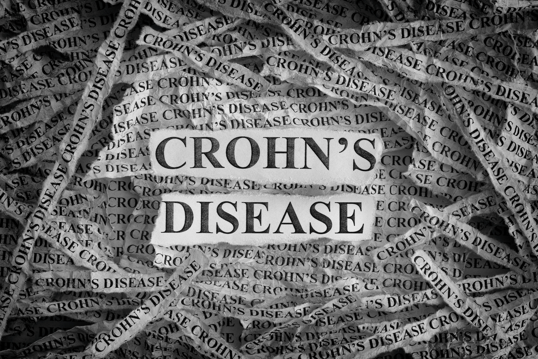 Torn pieces of paper with the words "Crohn's Disease"