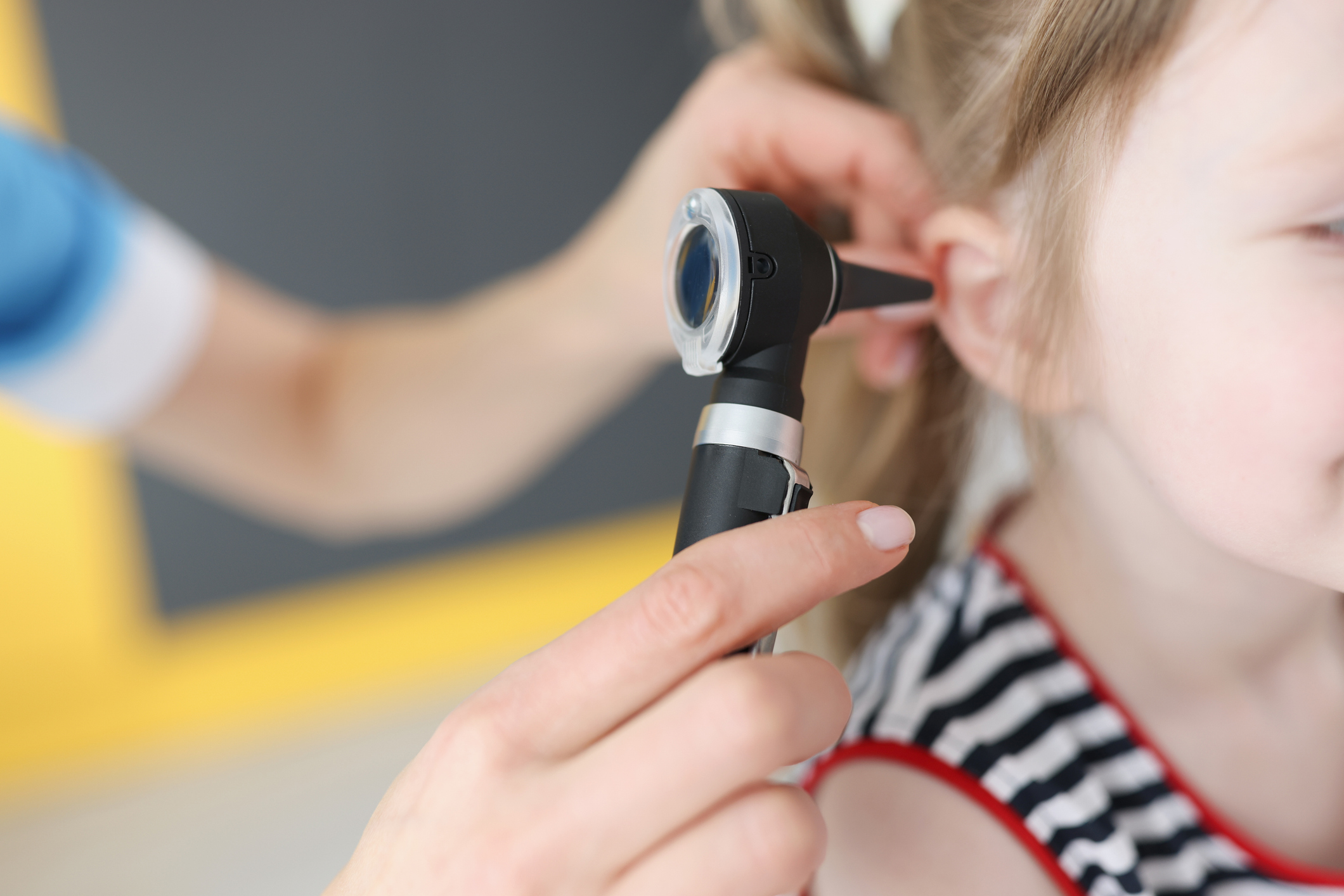 Close-up of child getting ear examined with otoscope