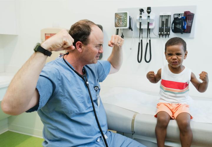 urgent care doctor and patient showing off their muscles