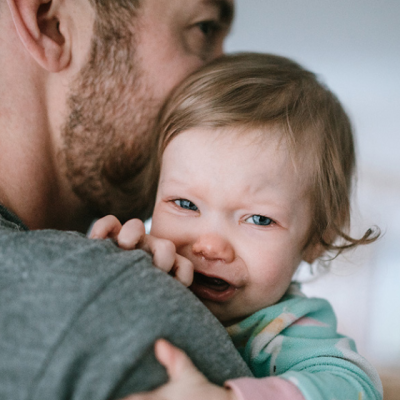 baby with RSV crying on dad's shoulder